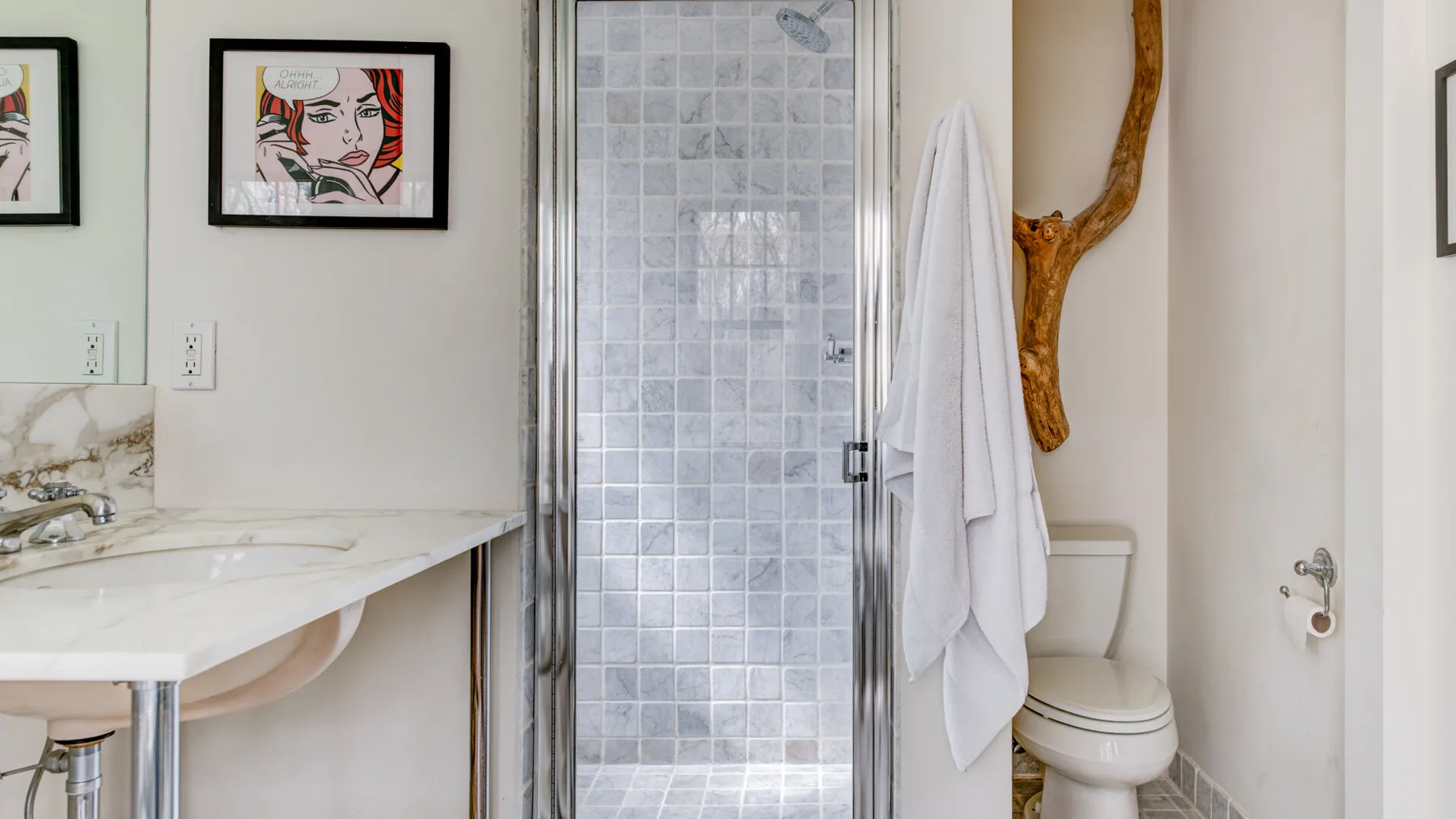 Un baño con ducha de vidrio, lavabo e inodoro.