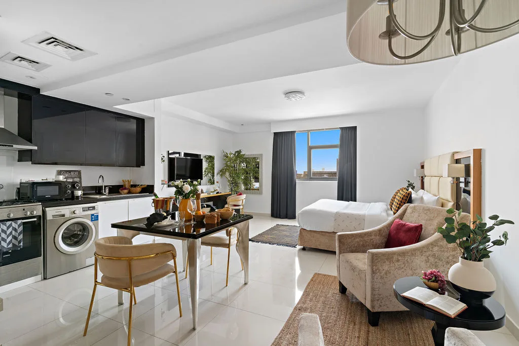 An open-plan living room and kitchen with a dining table and seating.