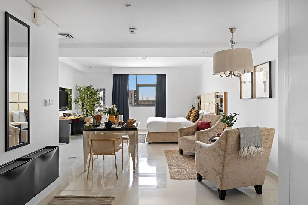 Una sala luminosa con asientos, una mesa de comedor y una ventana grande.