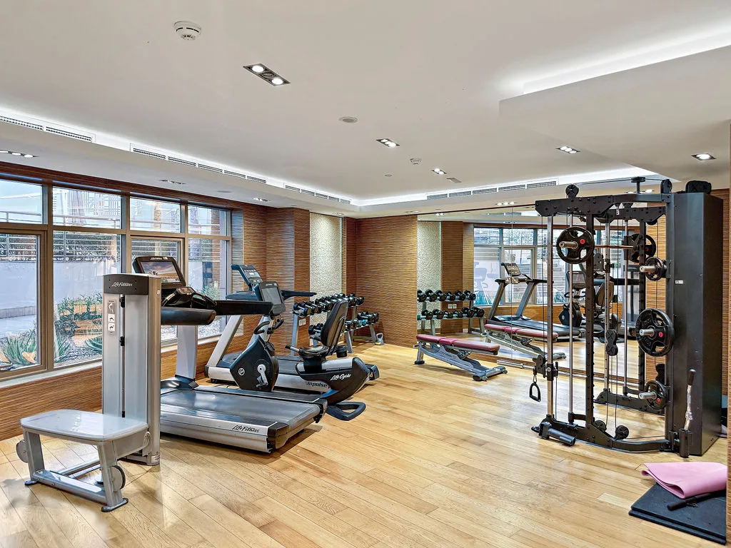 A gym with treadmills, exercise bikes, and weight-training equipment.