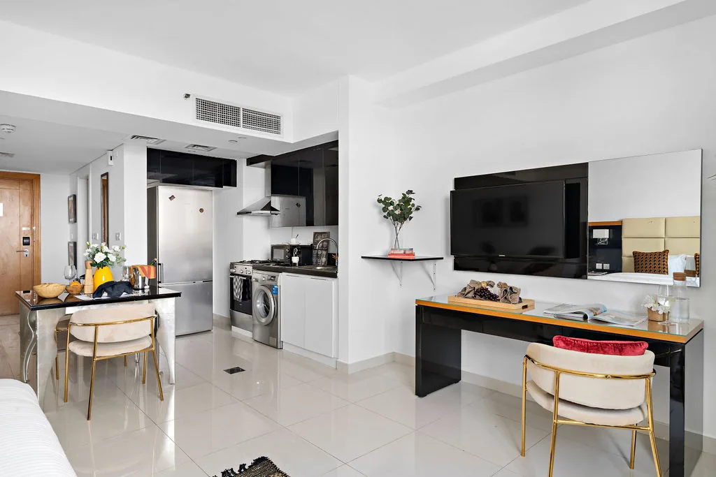 An open-plan kitchen and dining area with a television above a counter.