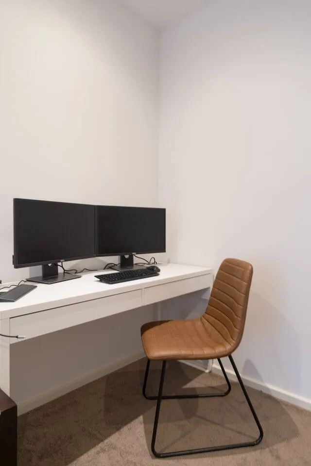 Boost your productivity in the dedicated workspace with a swivel chair, dual monitor setup, keyboard, and mouse—perfect for a seamless and comfortable remote work experience.
