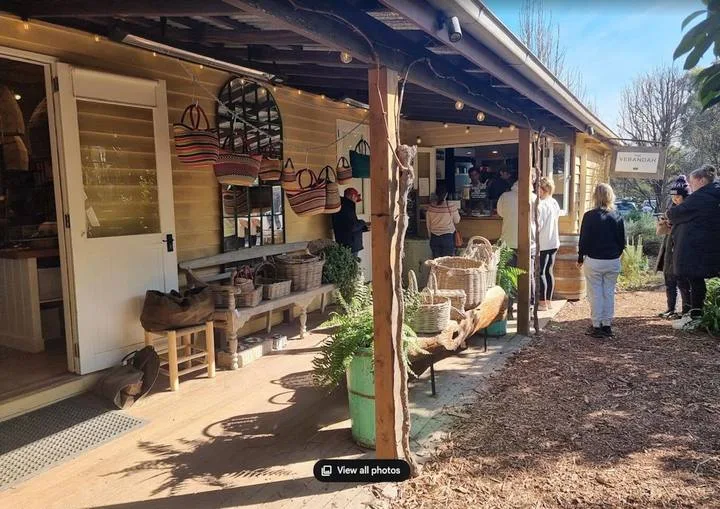 A covered outdoor shop displays woven baskets and bags beside its entrance.