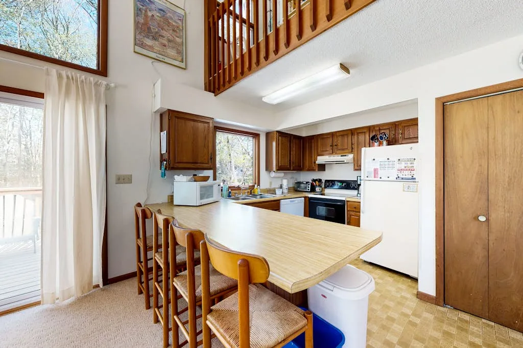 An open kitchen with a long wooden island and bar seating.