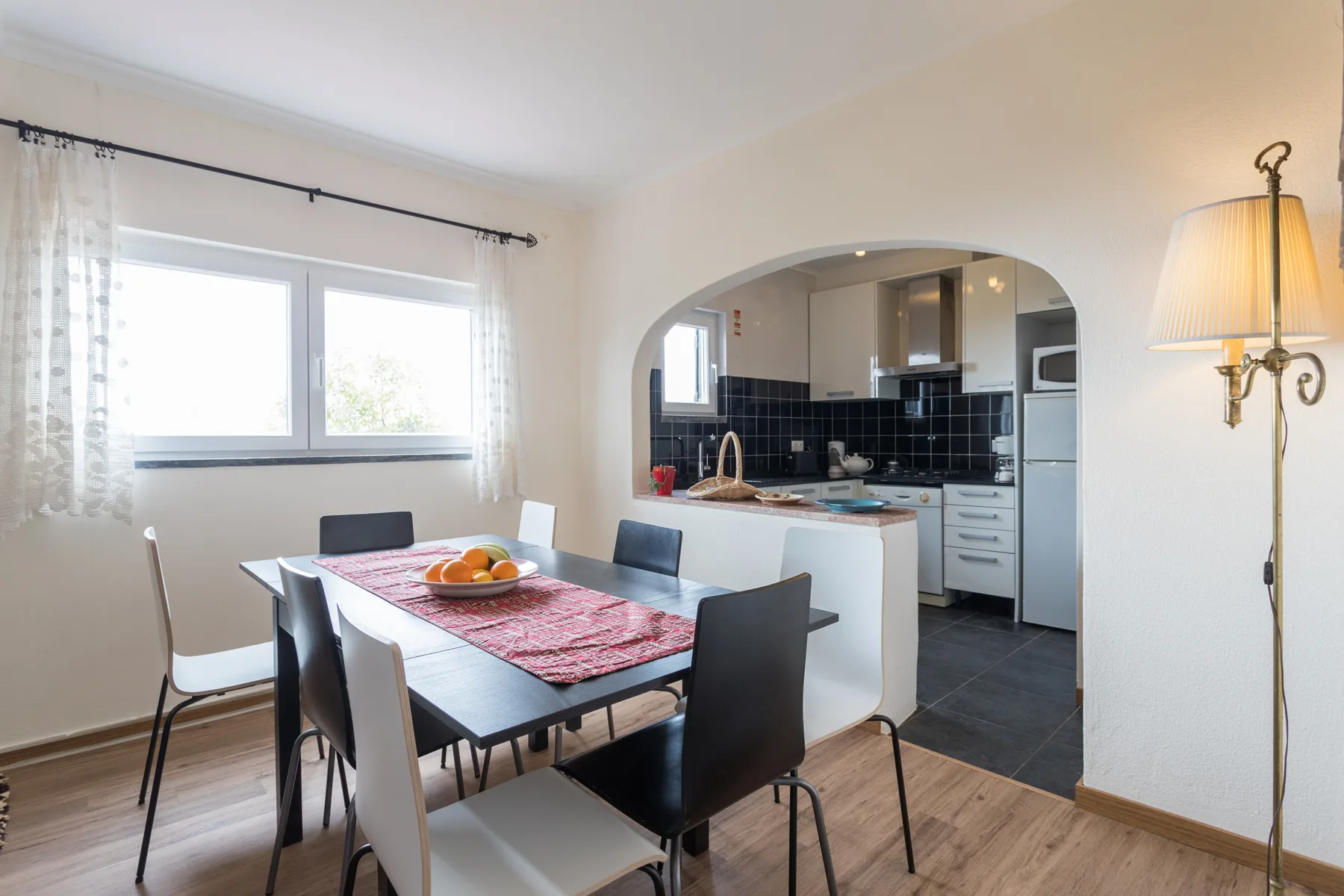 A dining area opens onto a kitchen through a wide archway.