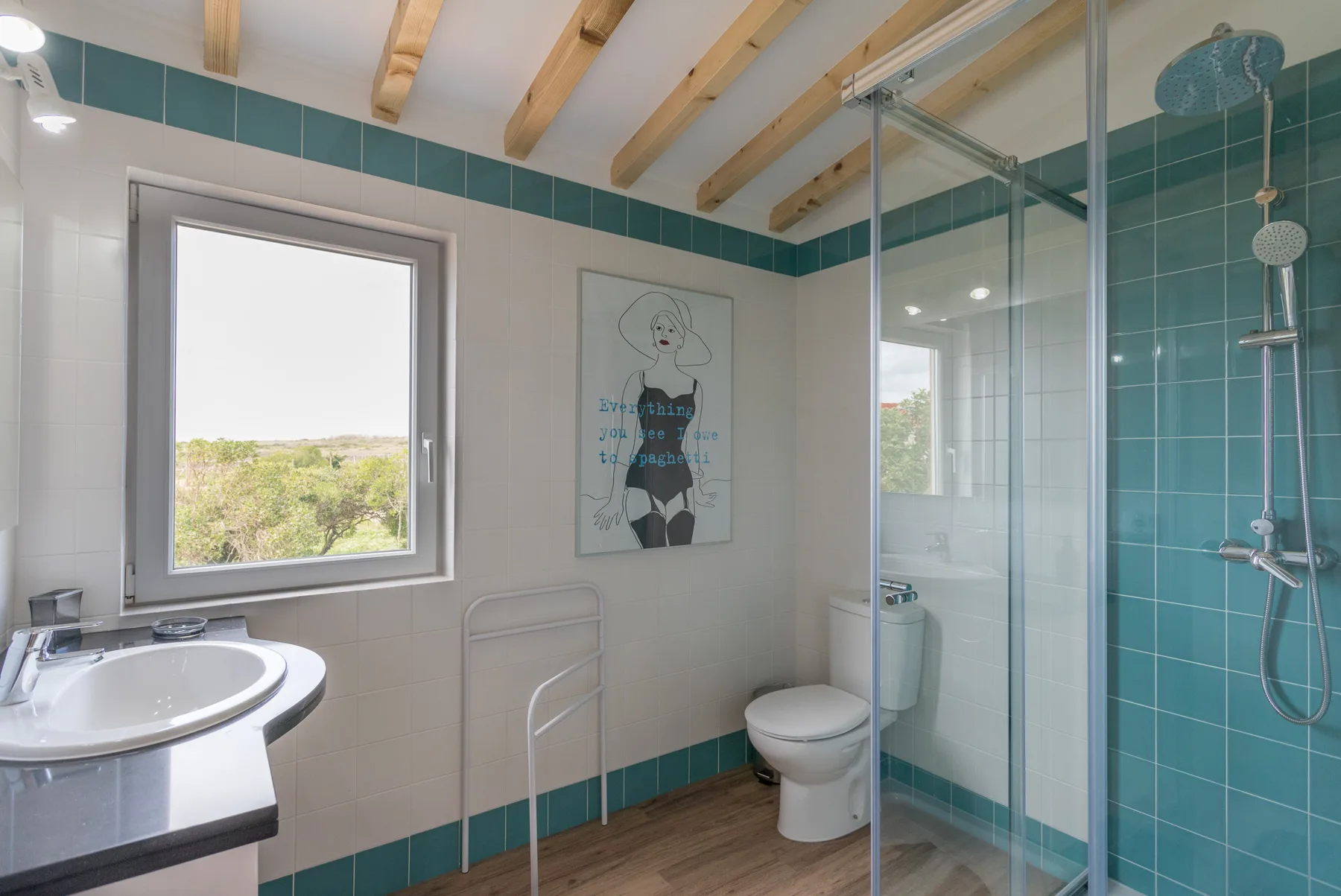 A tiled bathroom with a sink, toilet, and glass shower.