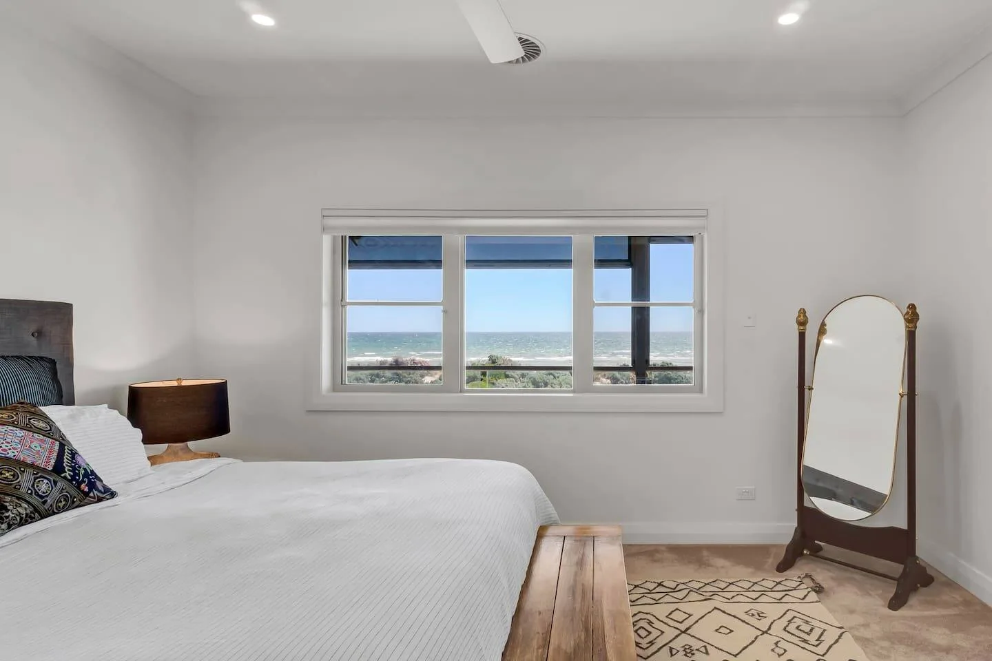 Un dormitorio con una cama, una ventana y vistas al agua.