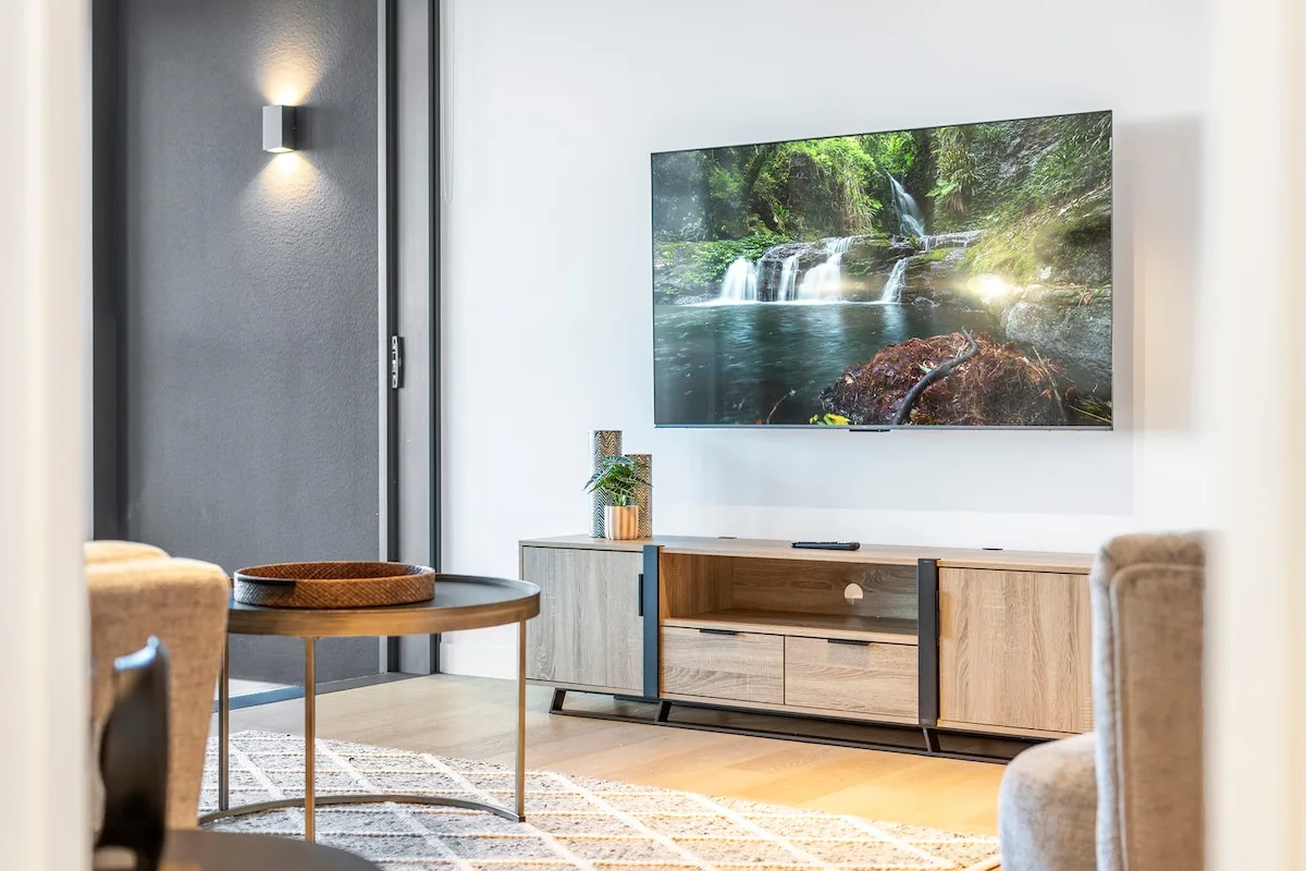 Una sala de estar con un televisor sobre un mueble bajo de madera.