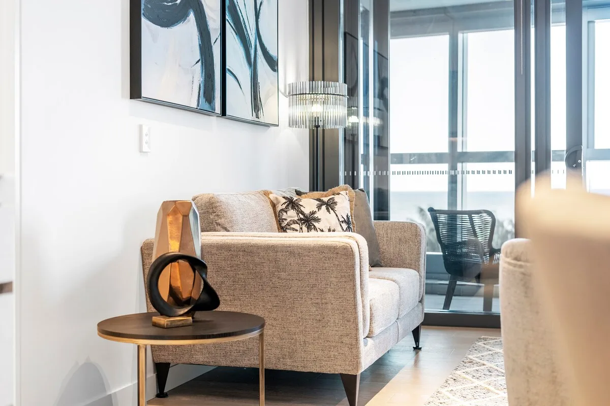 Una sala luminosa con asientos junto a ventanas de piso a techo.