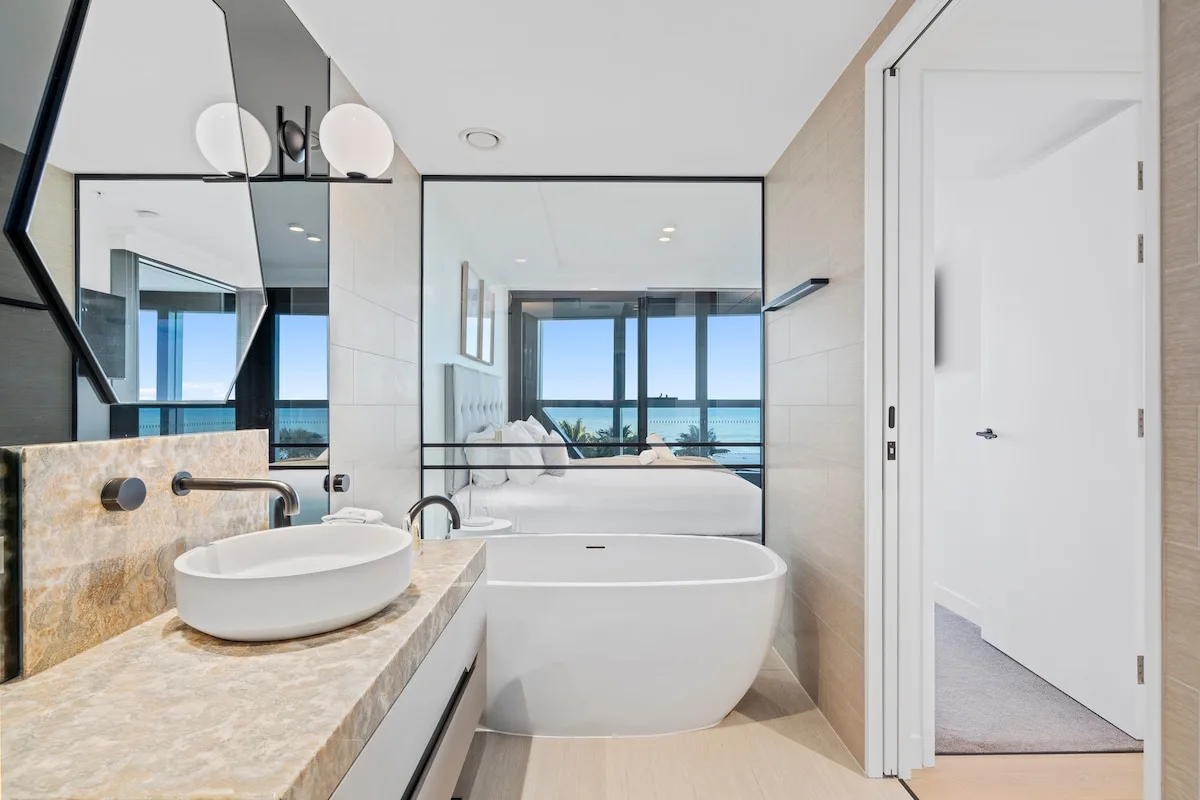 Un baño luminoso con bañera independiente y lavabo sobre encimera.