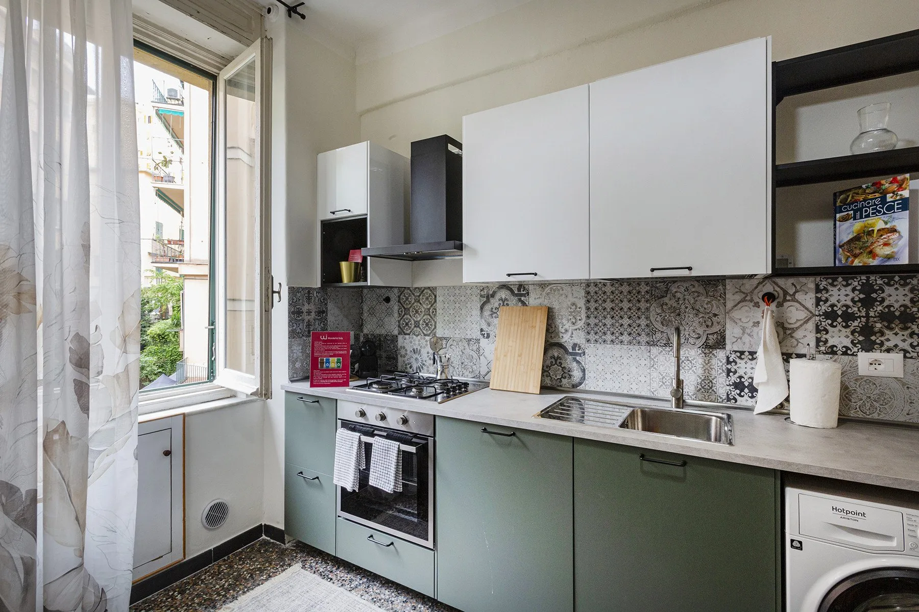 Una cocina luminosa con gabinetes claros, una encimera y una ventana grande.