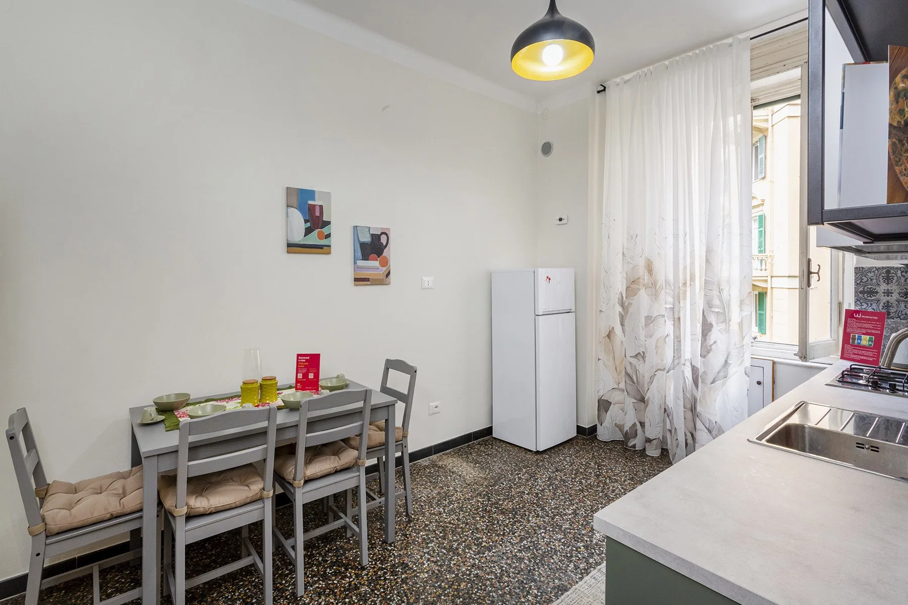 Una cocina compacta con zona de comedor y una mesa junto al refrigerador.