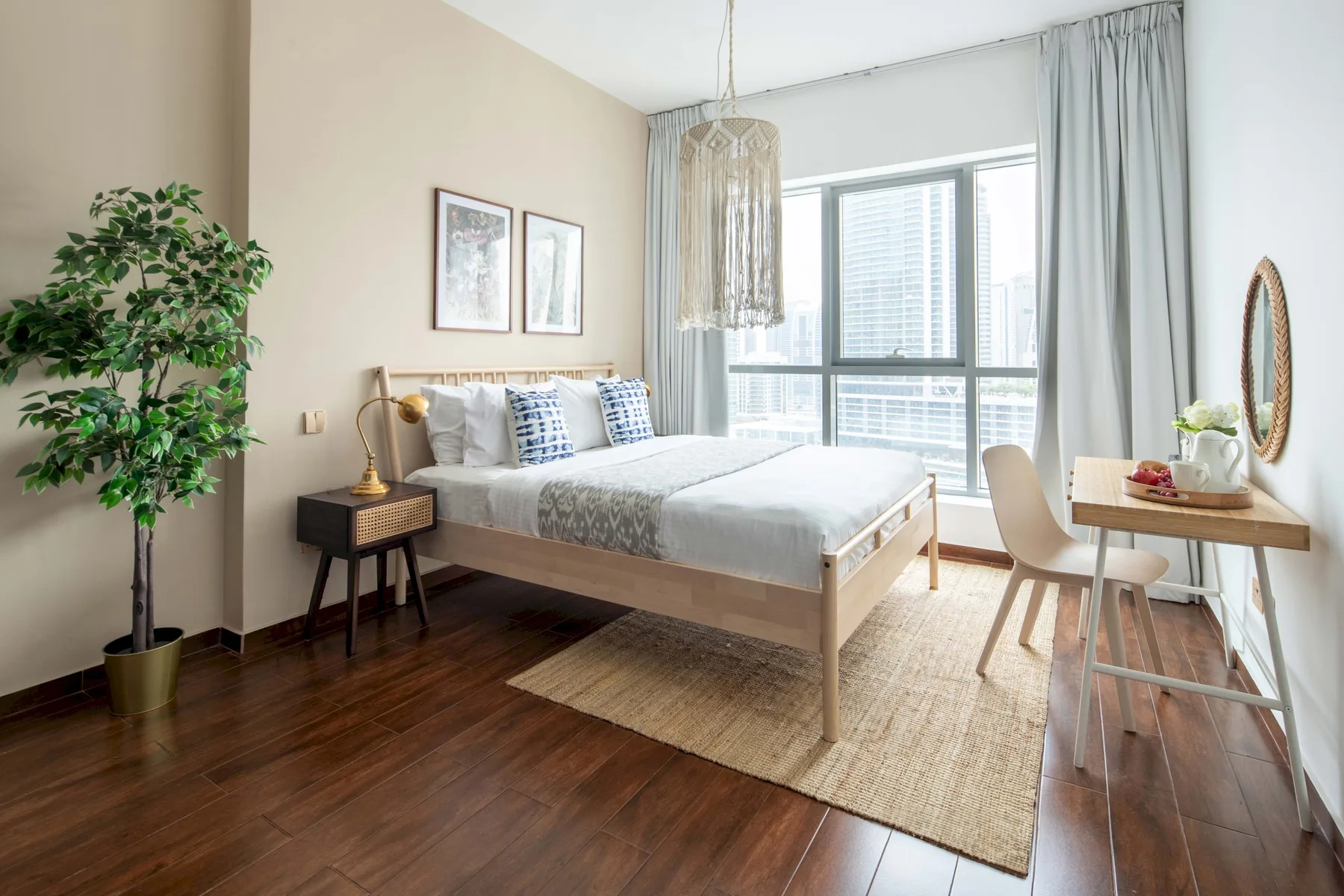 A bright bedroom with a bed, bedside table, and large windows.