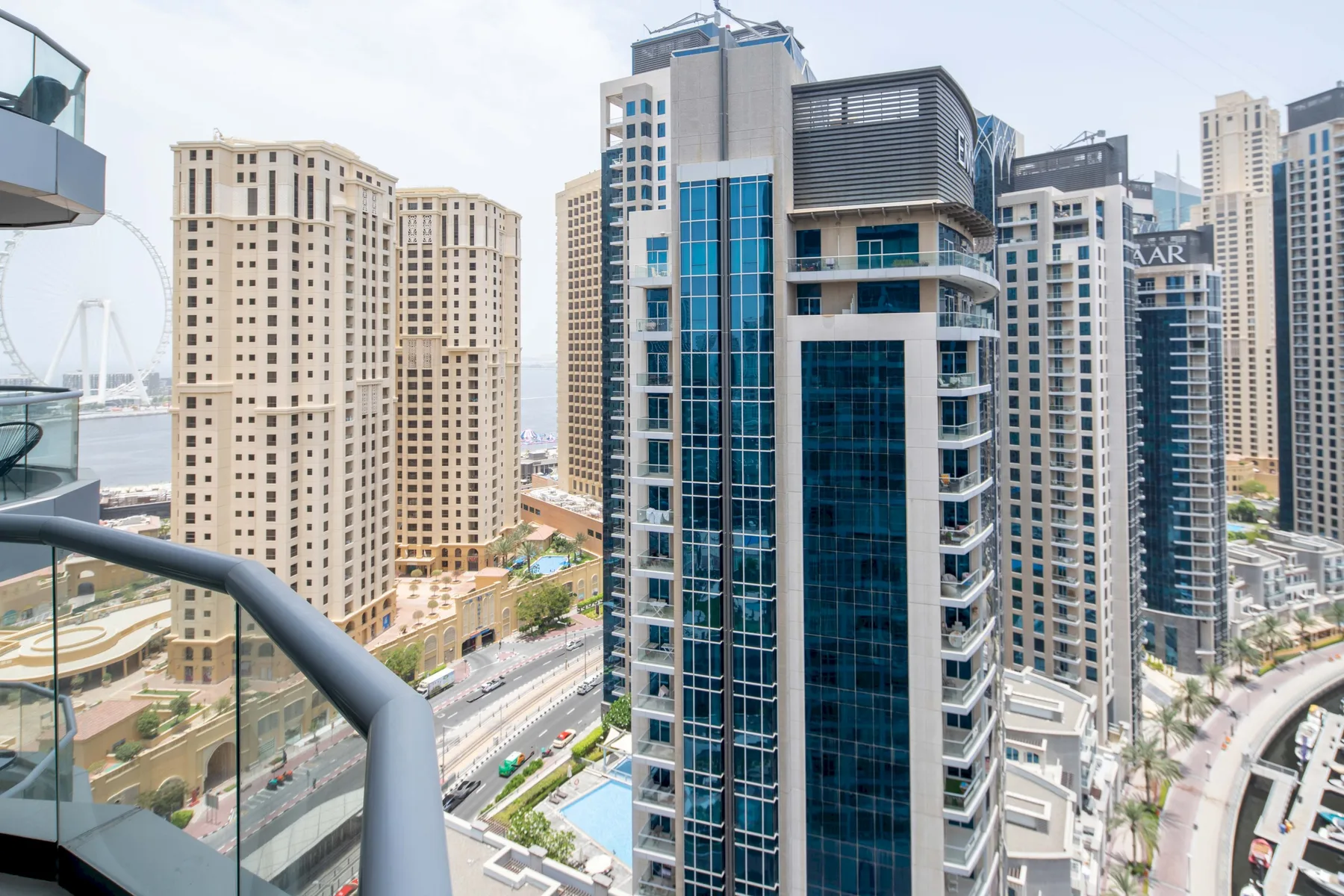 Cityscape of high-rise buildings viewed from a balcony.