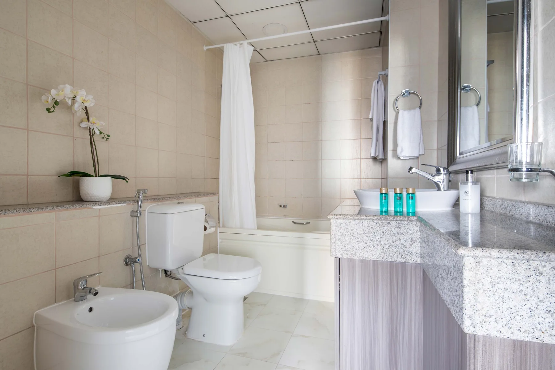 A tiled bathroom with a bathtub, toilet, and sink.