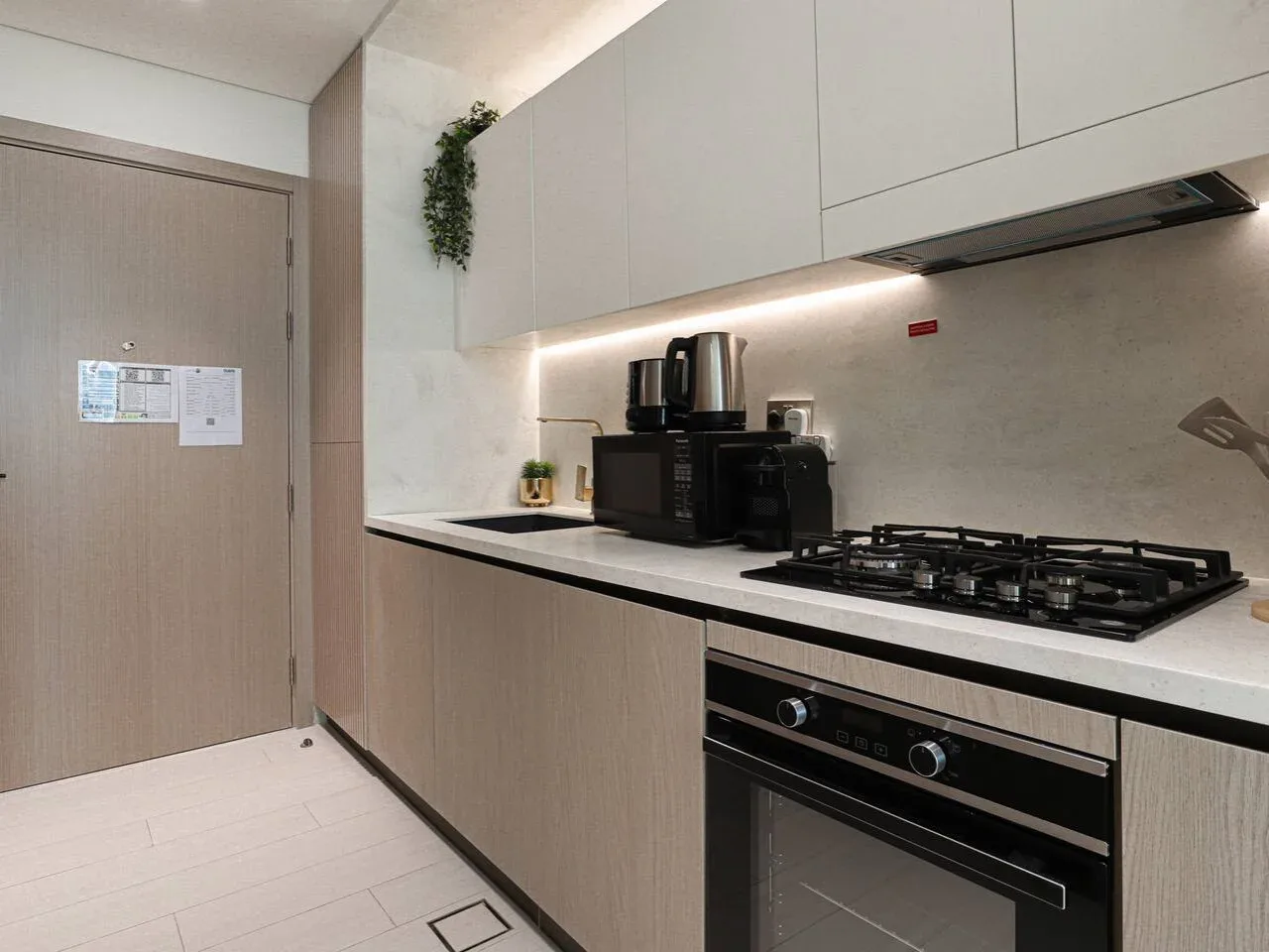 A modern kitchen with a countertop, cooktop, and built-in oven.