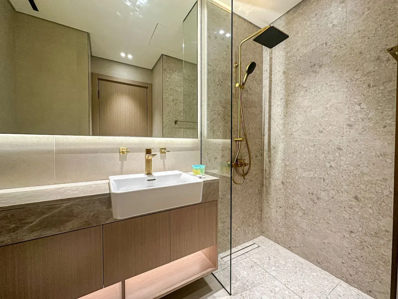 A modern bathroom with a wall-mounted sink and shower.