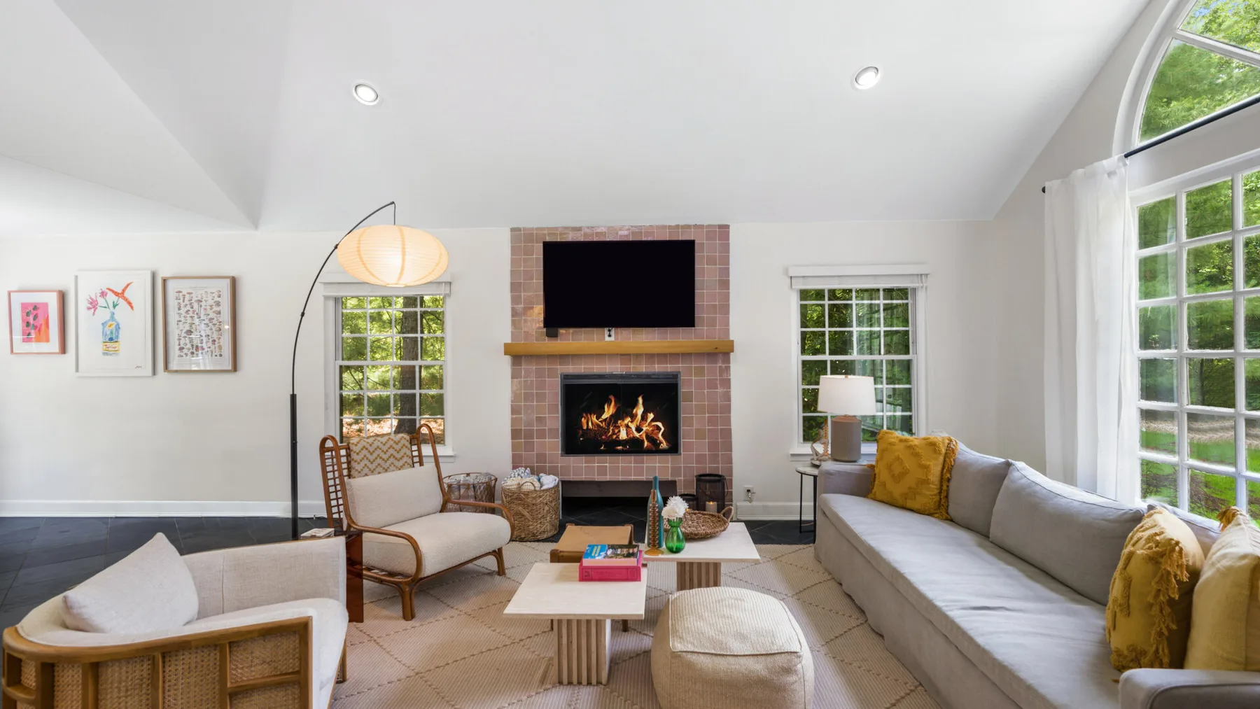 Una sala de estar luminosa con asientos alrededor de una chimenea y una mesa de centro.
