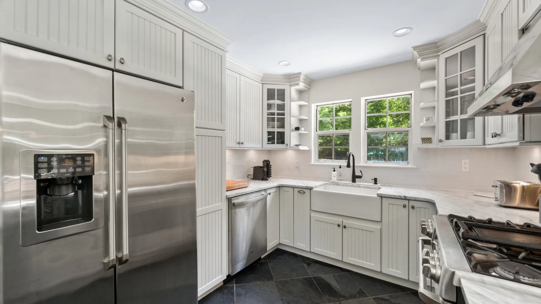 Una cocina luminosa con electrodomésticos de acero inoxidable y gabinetes blancos.