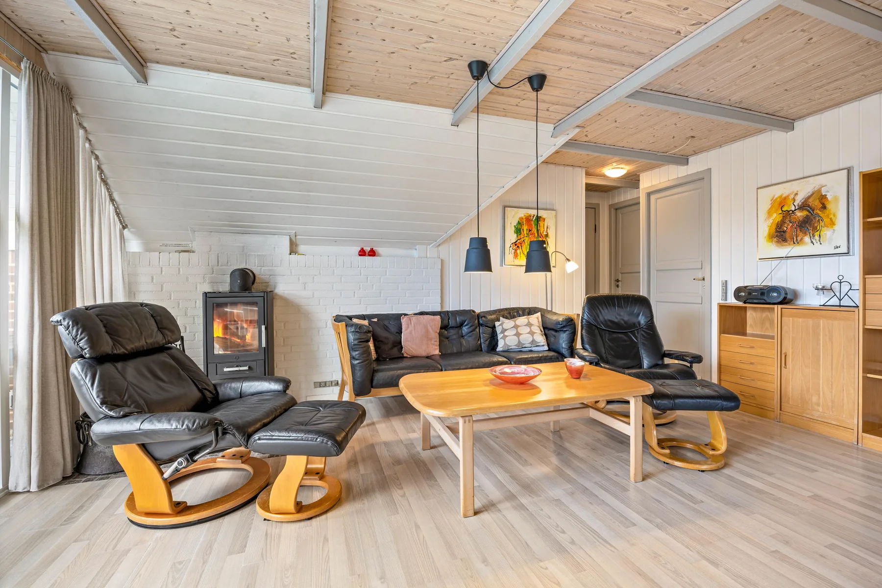 Una sala de estar con asientos alrededor de una mesa baja de madera y una chimenea.