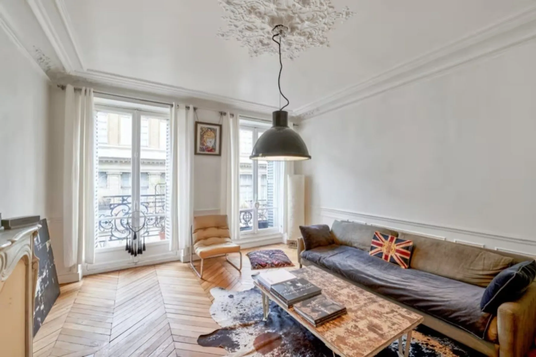 A bright living room with large windows, seating, and a coffee table.
