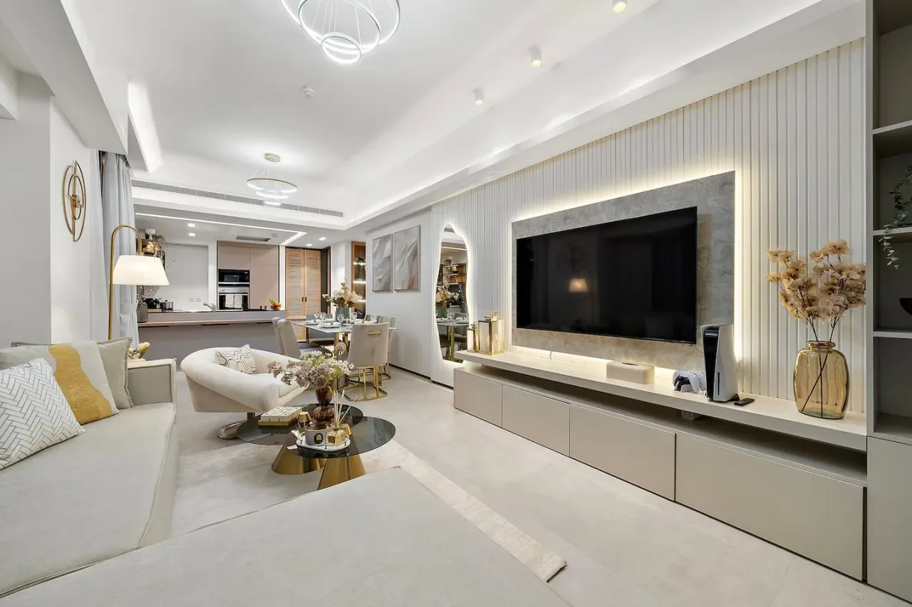 Una sala luminosa cuenta con un televisor grande y una zona de estar.