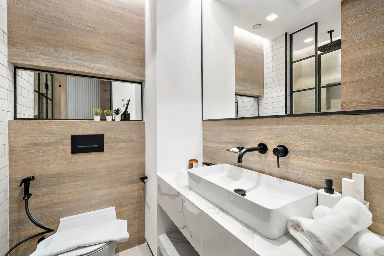 Un baño moderno con un lavabo blanco y un inodoro suspendido.