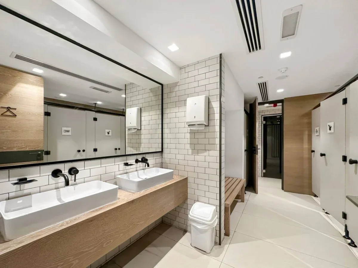 Un baño alicatado con dos lavabos y un mueble largo.