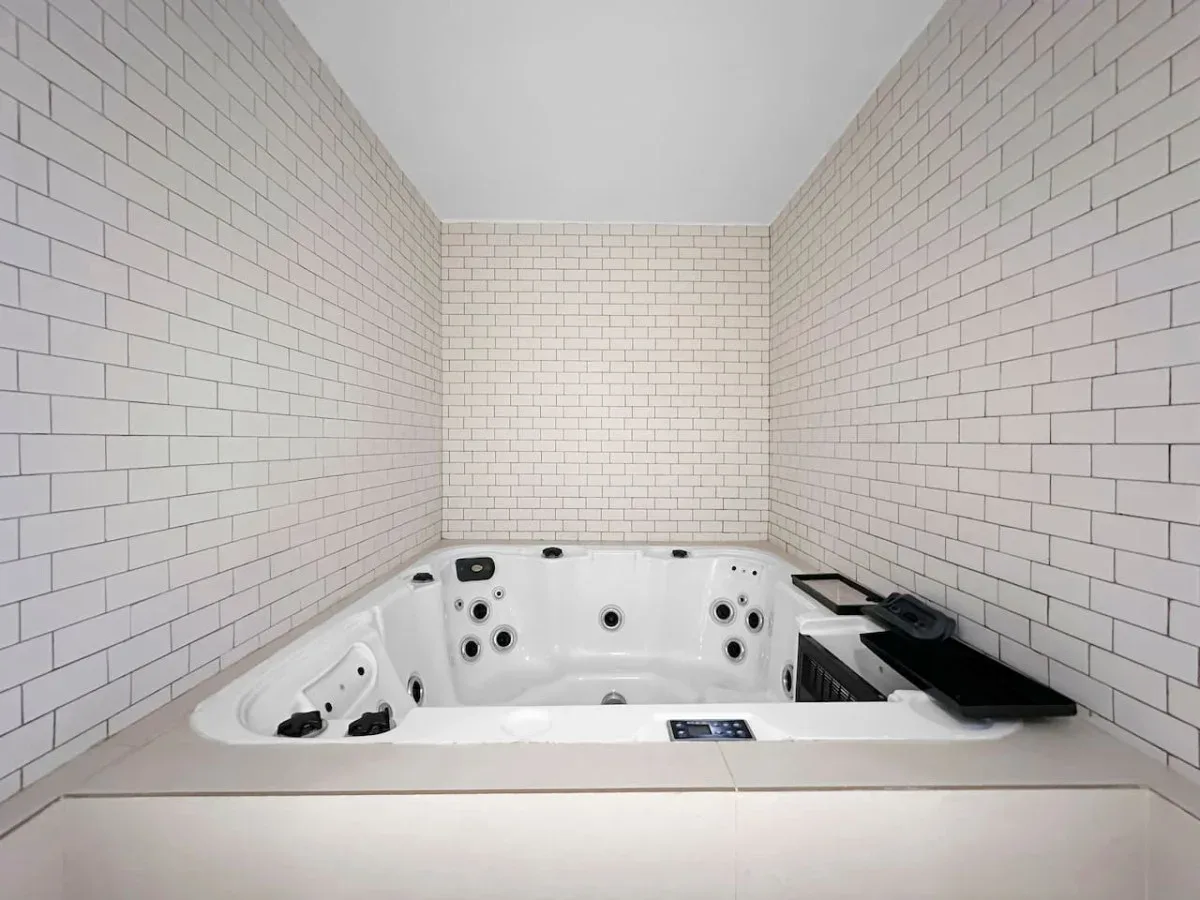 Un baño alicatado con una bañera de hidromasaje empotrada.