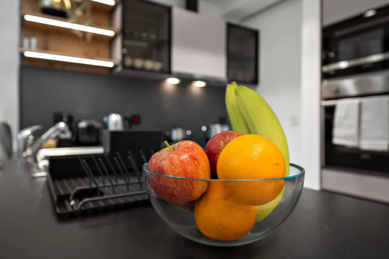 Un frutero de vidrio está sobre una encimera de cocina.