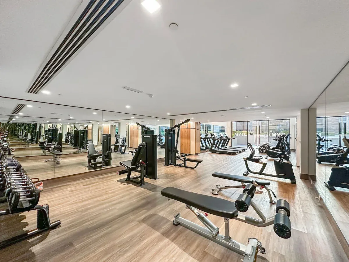 Una sala de entrenamiento con máquinas de ejercicio y equipo de pesas.