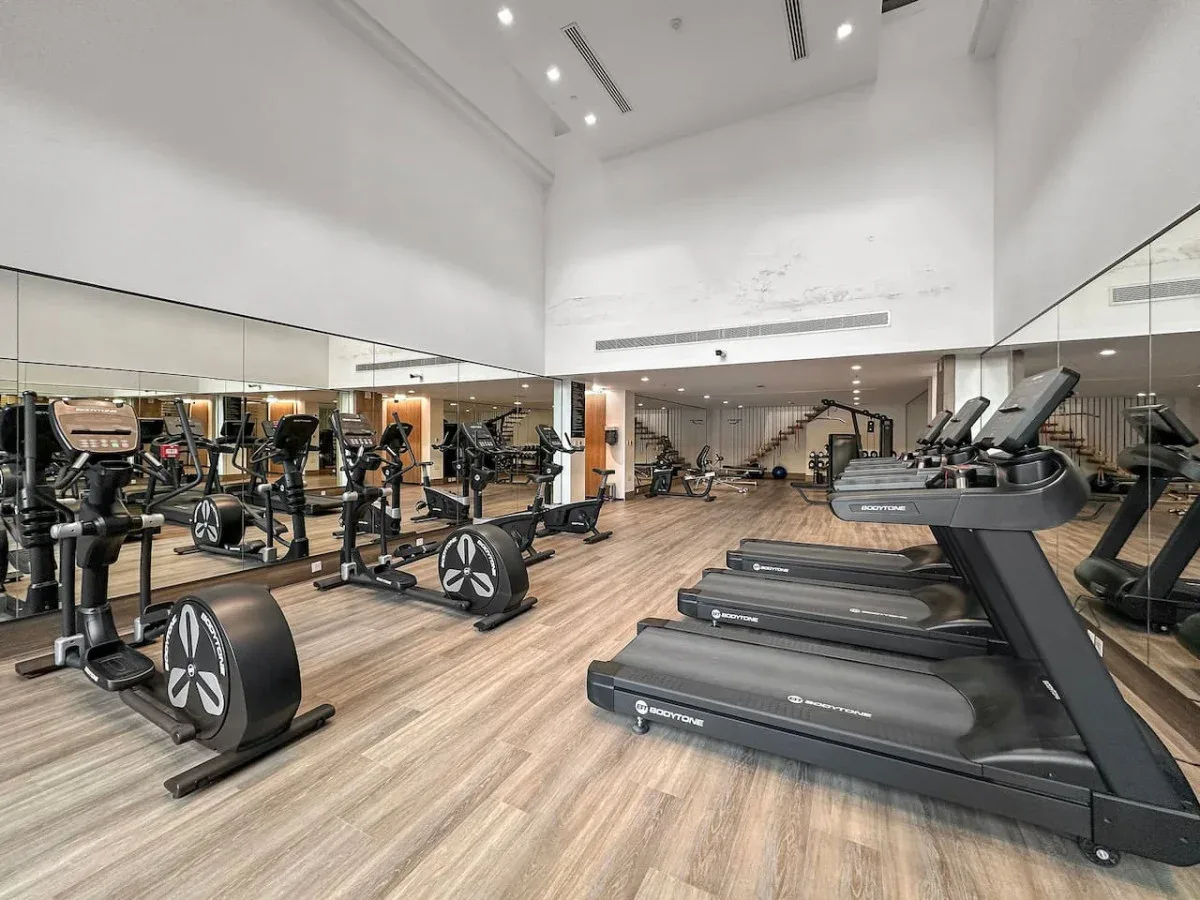 Un gimnasio luminoso con cintas de correr y bicicletas estáticas.