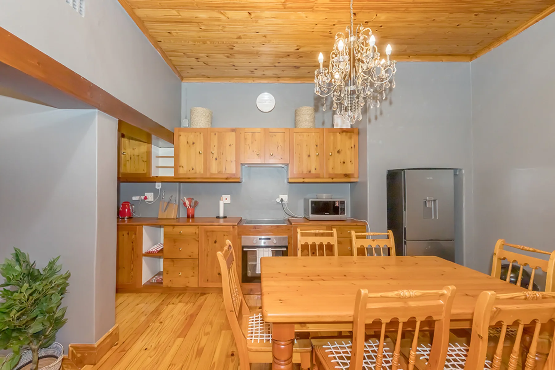 Una cocina y comedor con gabinetes de madera y una mesa grande.