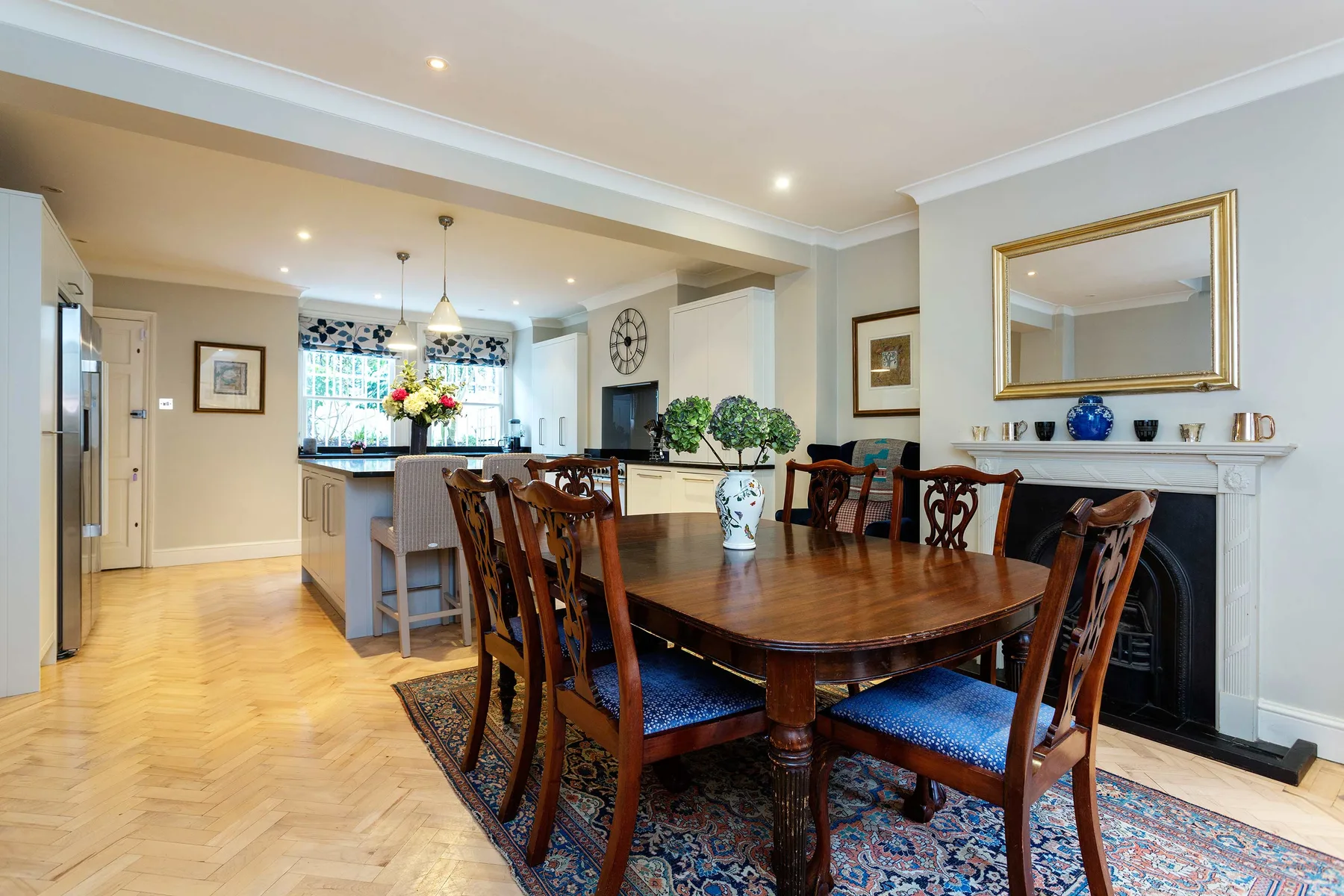 A dining room with a wooden table and seating beside a fireplace.