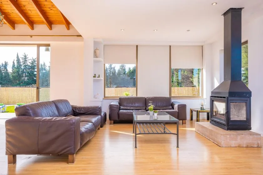 A bright living room with seating, a coffee table, and a fireplace.