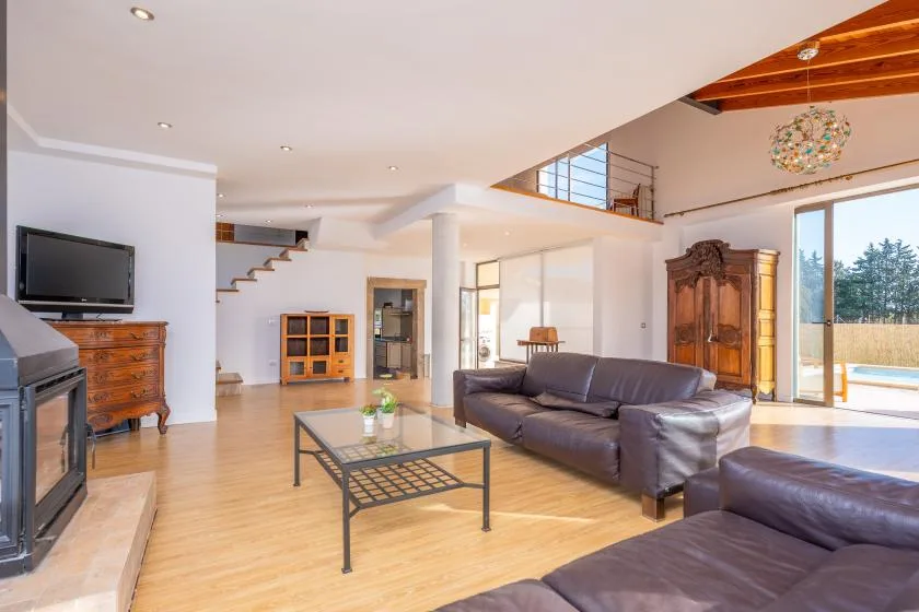 A bright living room with leather seating and a glass coffee table.