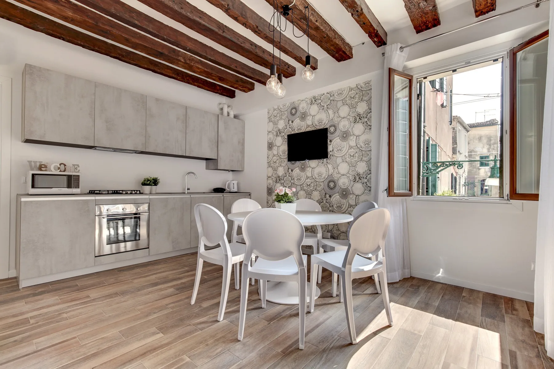Una cocina luminosa con comedor, mesa, asientos y una ventana grande.