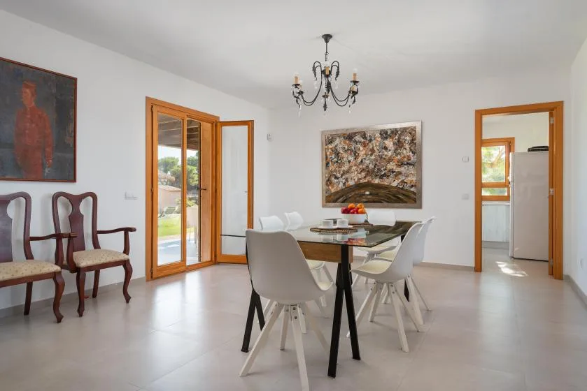 A bright dining area with a table, seating, and artwork on the walls.