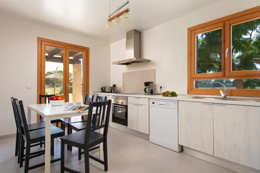 A bright kitchen and dining area with a table beside the cooking counter.