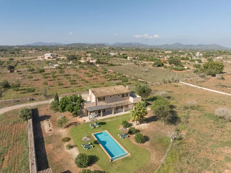 Aerial view of a countryside house with a swimming pool and surrounding fields.