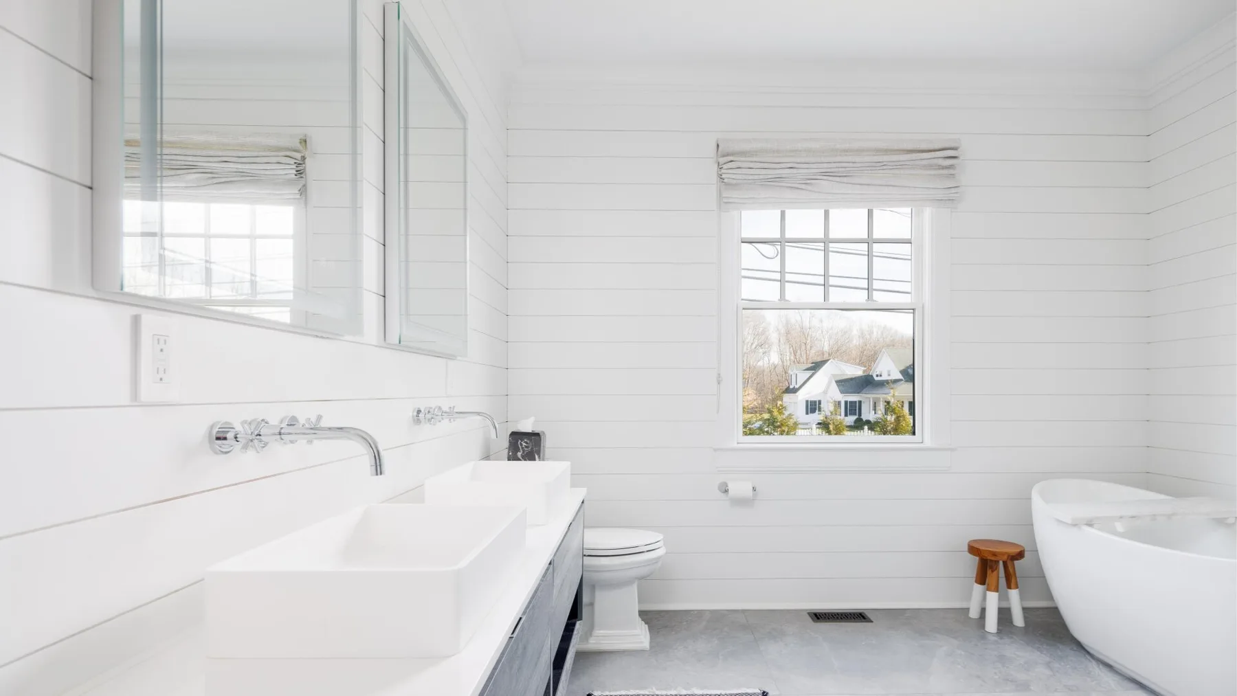 A bright bathroom with a bathtub, sink, and window.