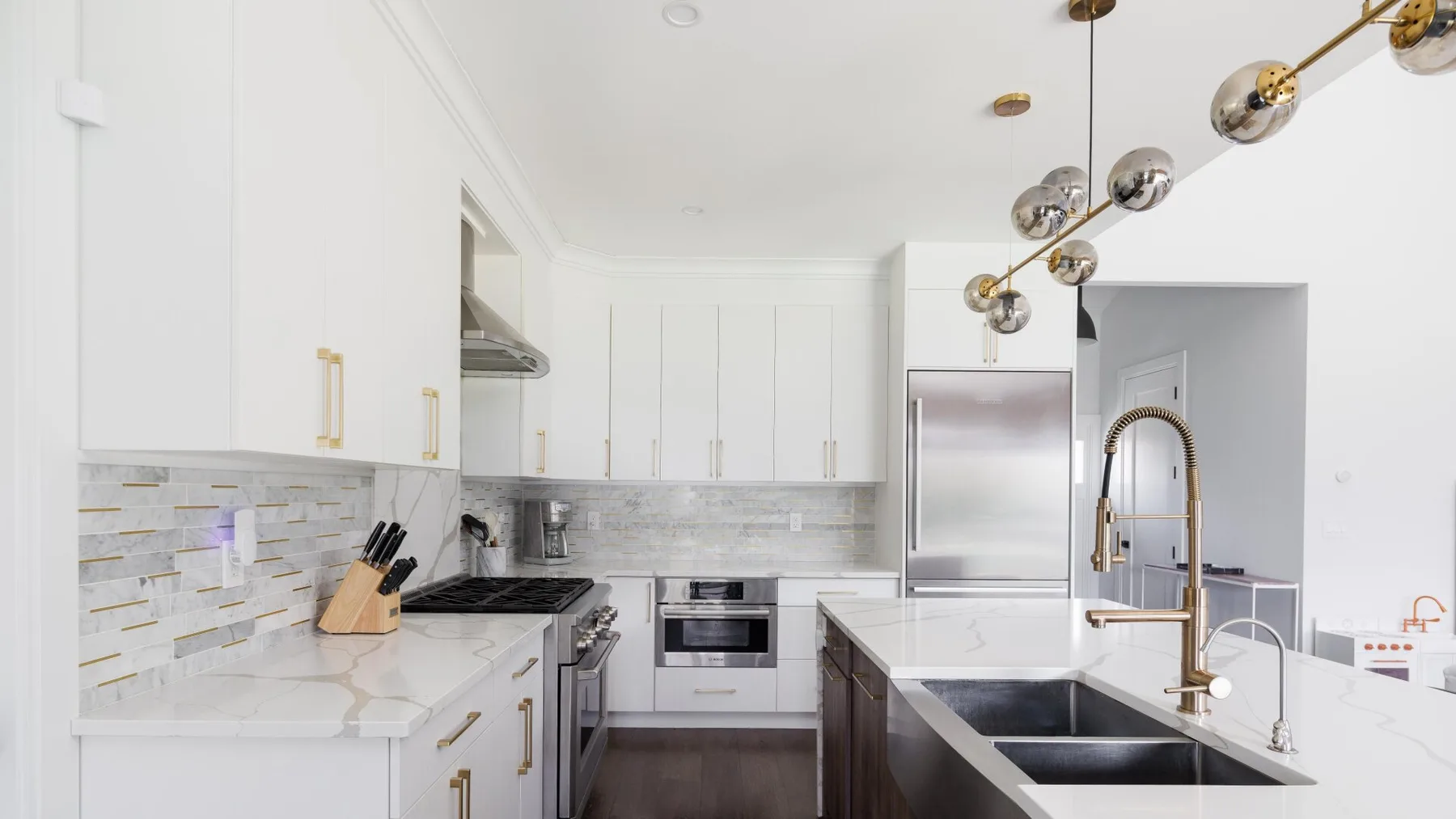A bright kitchen with white cabinetry, a central island, and a stainless-steel refrigerator.