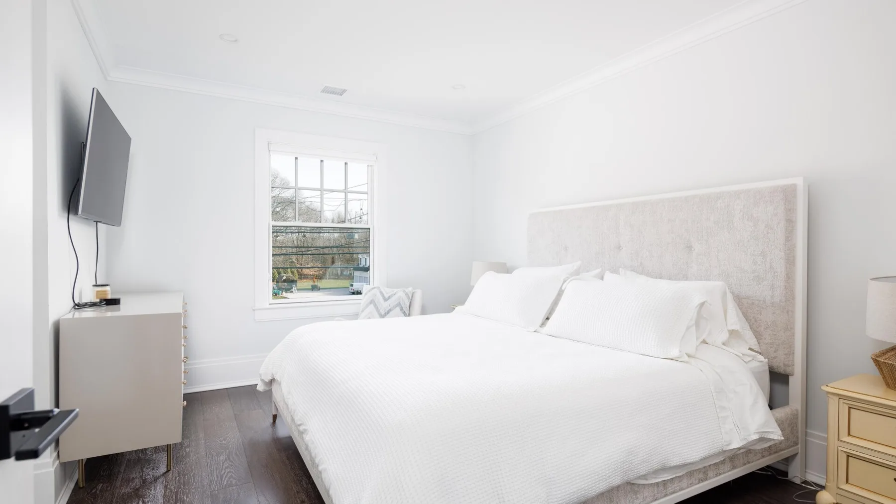 A bright bedroom with a large bed and a window.