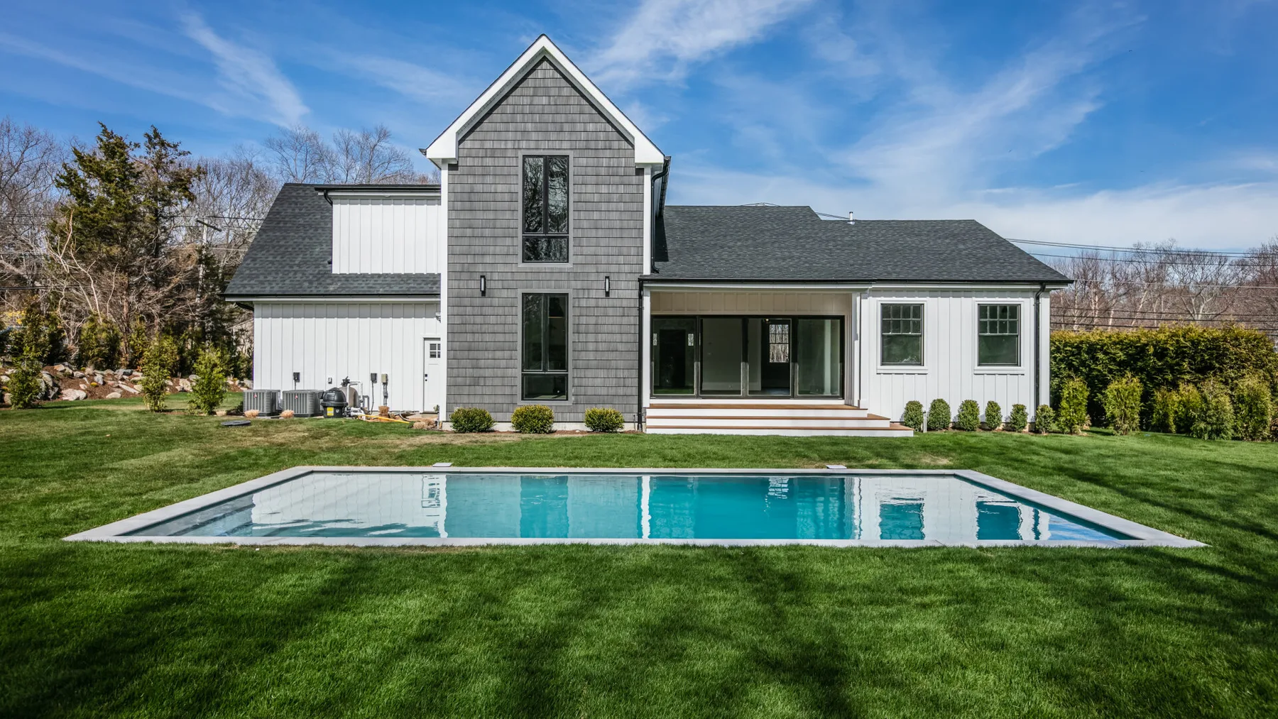 A modern house with a swimming pool set in a green lawn.