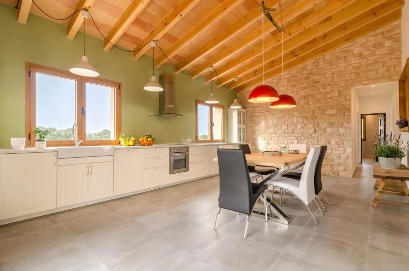 Una luminosa cocina y comedor con una encimera larga y una mesa de comedor.