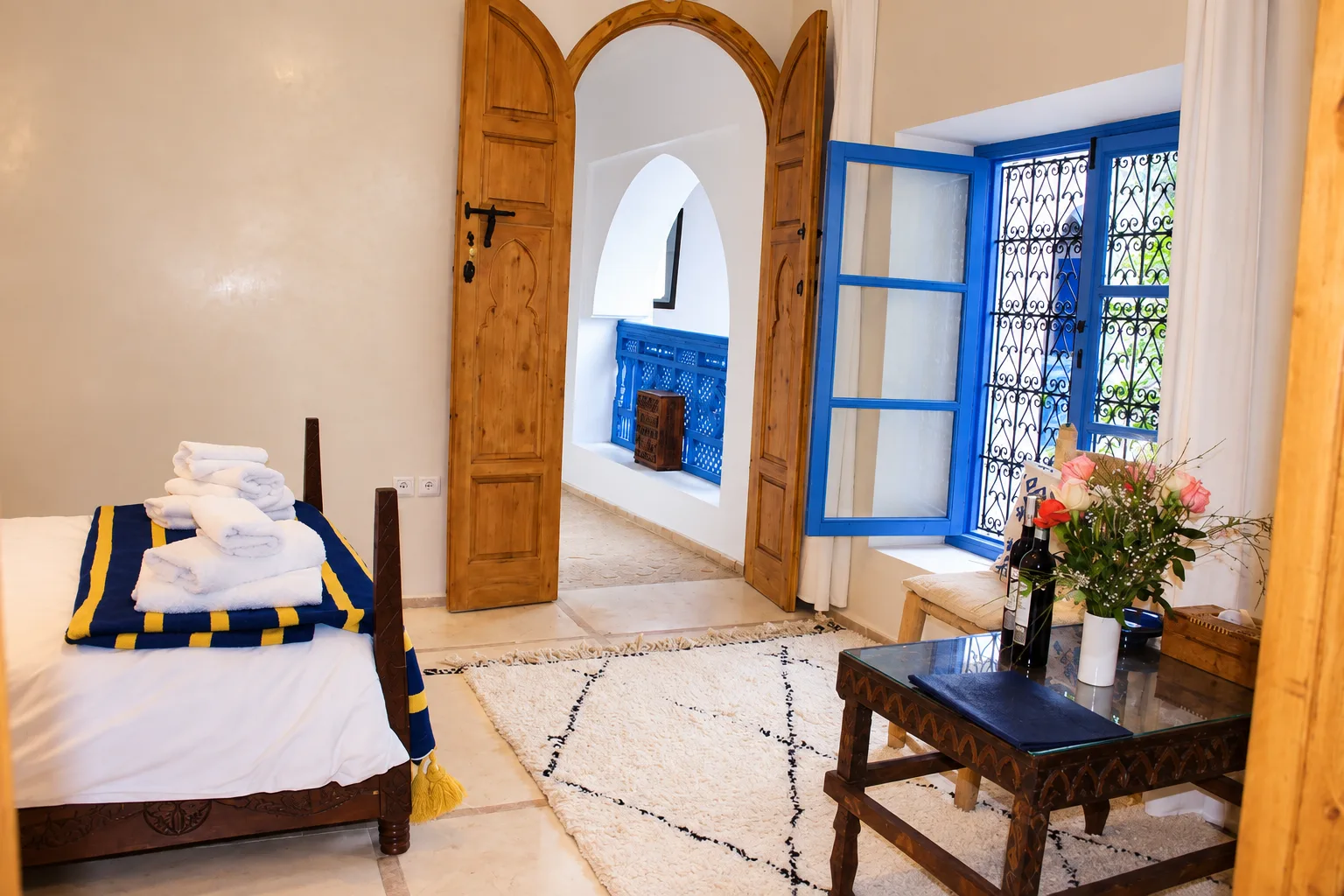 Dormitorio con marco de ventana azul y una puerta que da al balcón