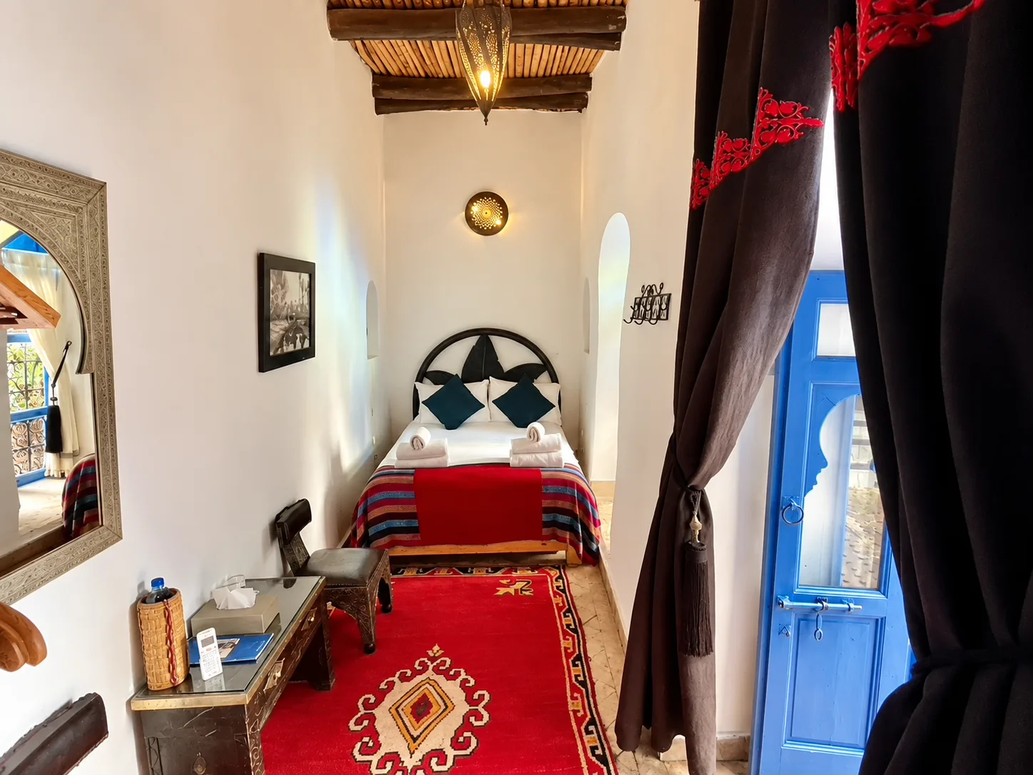Dormitorio con una cama doble y almohadas de color verde azulado