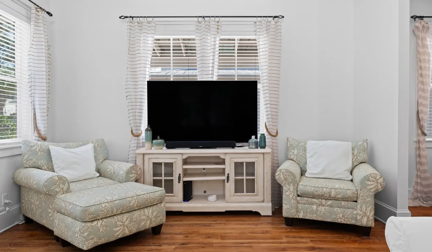Una sala de estar con un televisor entre dos asientos tapizados.