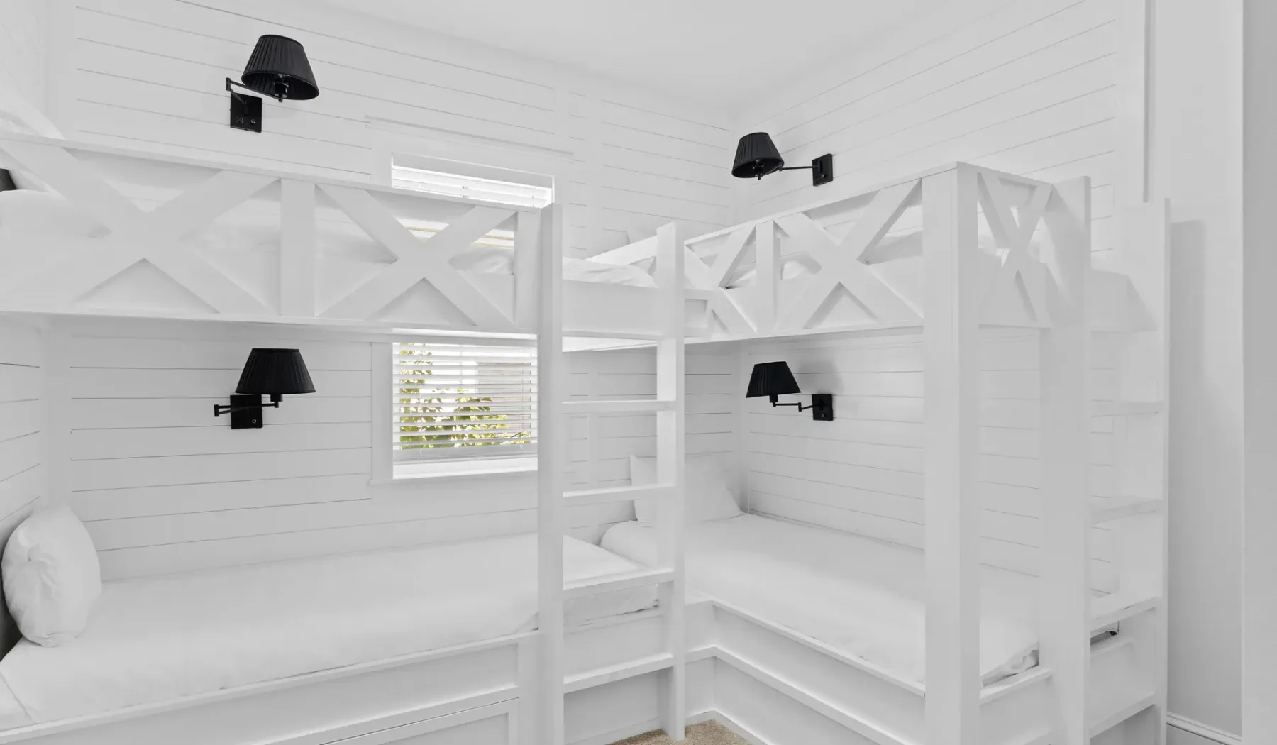 Un dormitorio luminoso con literas empotradas y una ventana pequeña.