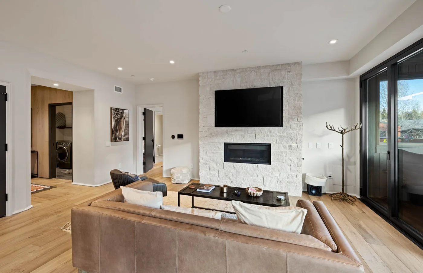 Una luminosa sala de estar con chimenea de piedra, televisor y asientos.